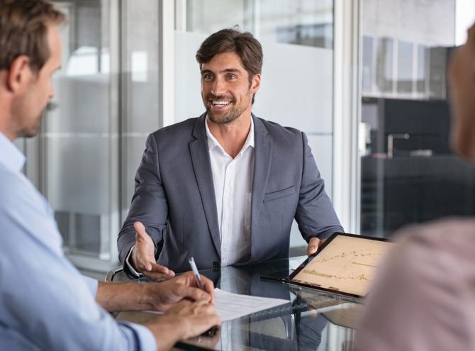 Financial agent showing growth graph to couple.